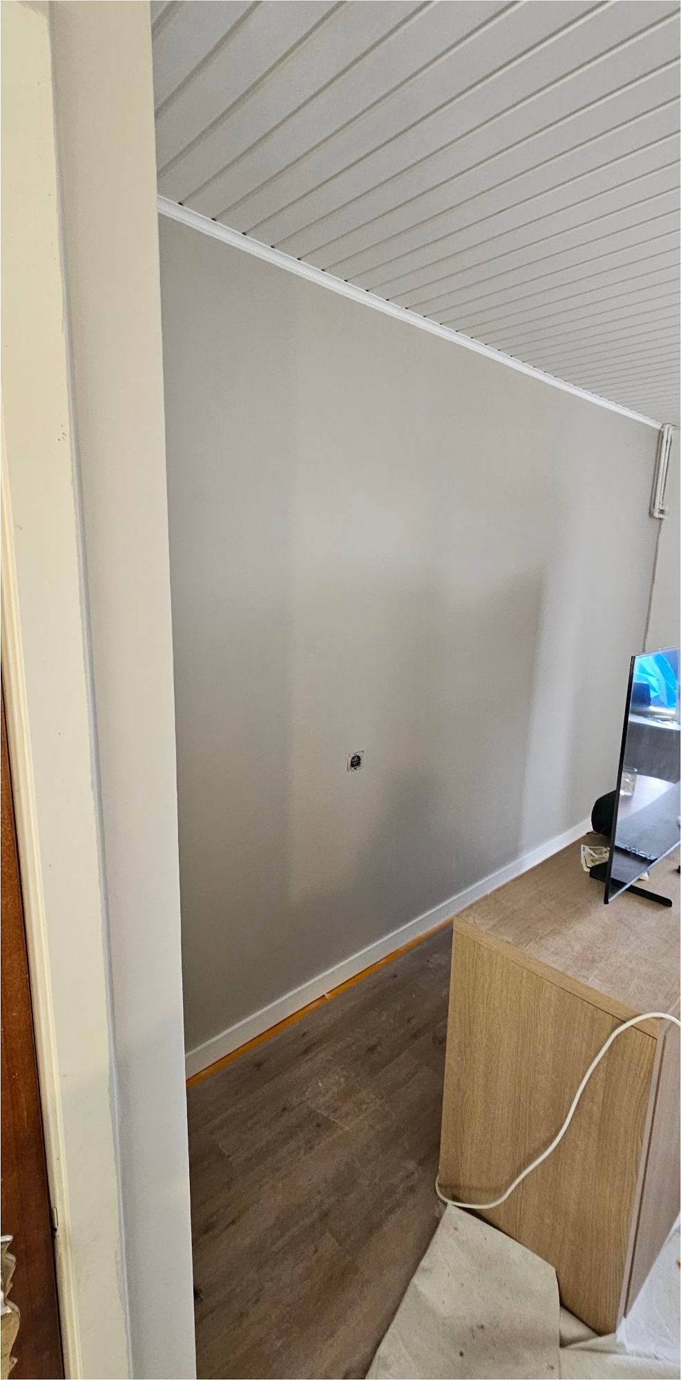 Zolderkamer met glad gestuukte wanden en een schuin plafond